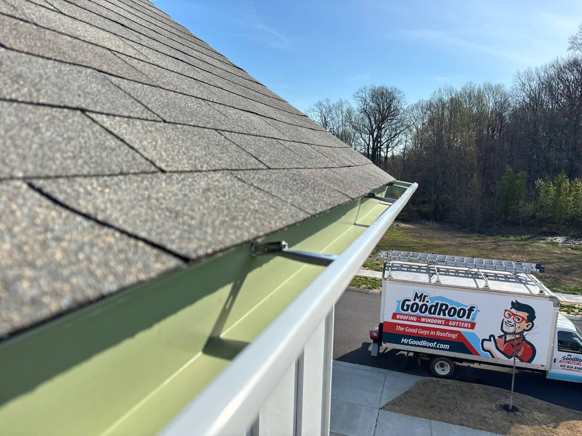 Two men in a white van going to fix gutters for mr goodroof
