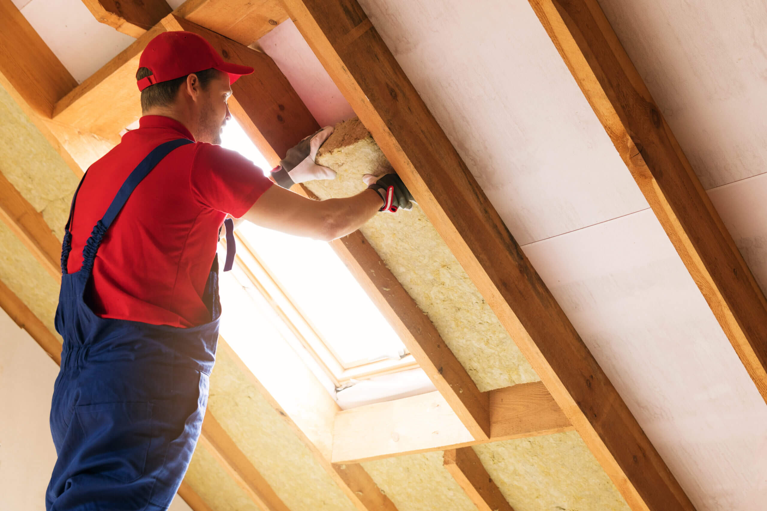 Man working on insulation for an attic space