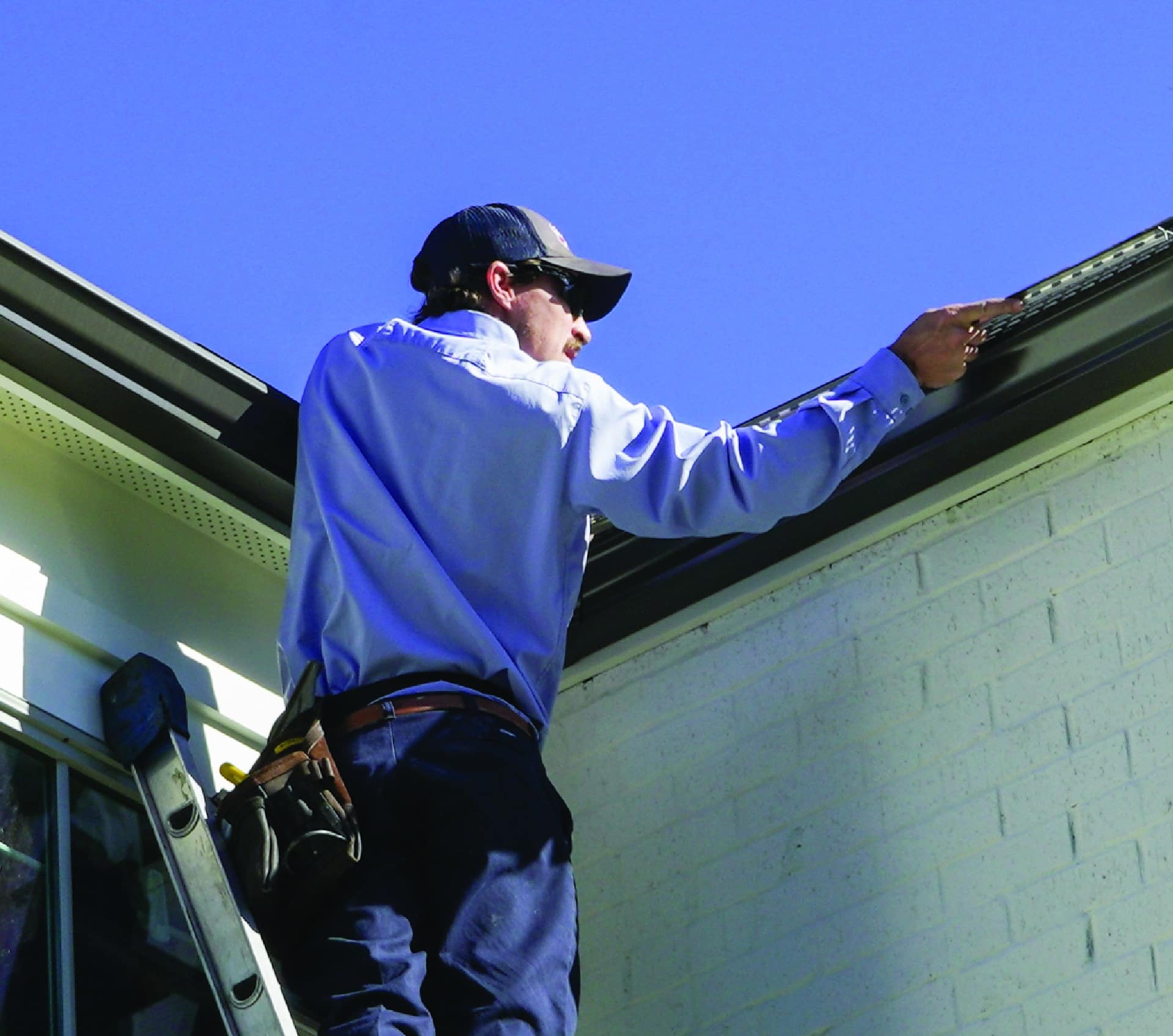 A Mr Goodroof technician working on a gutter on a home in nashville tn
